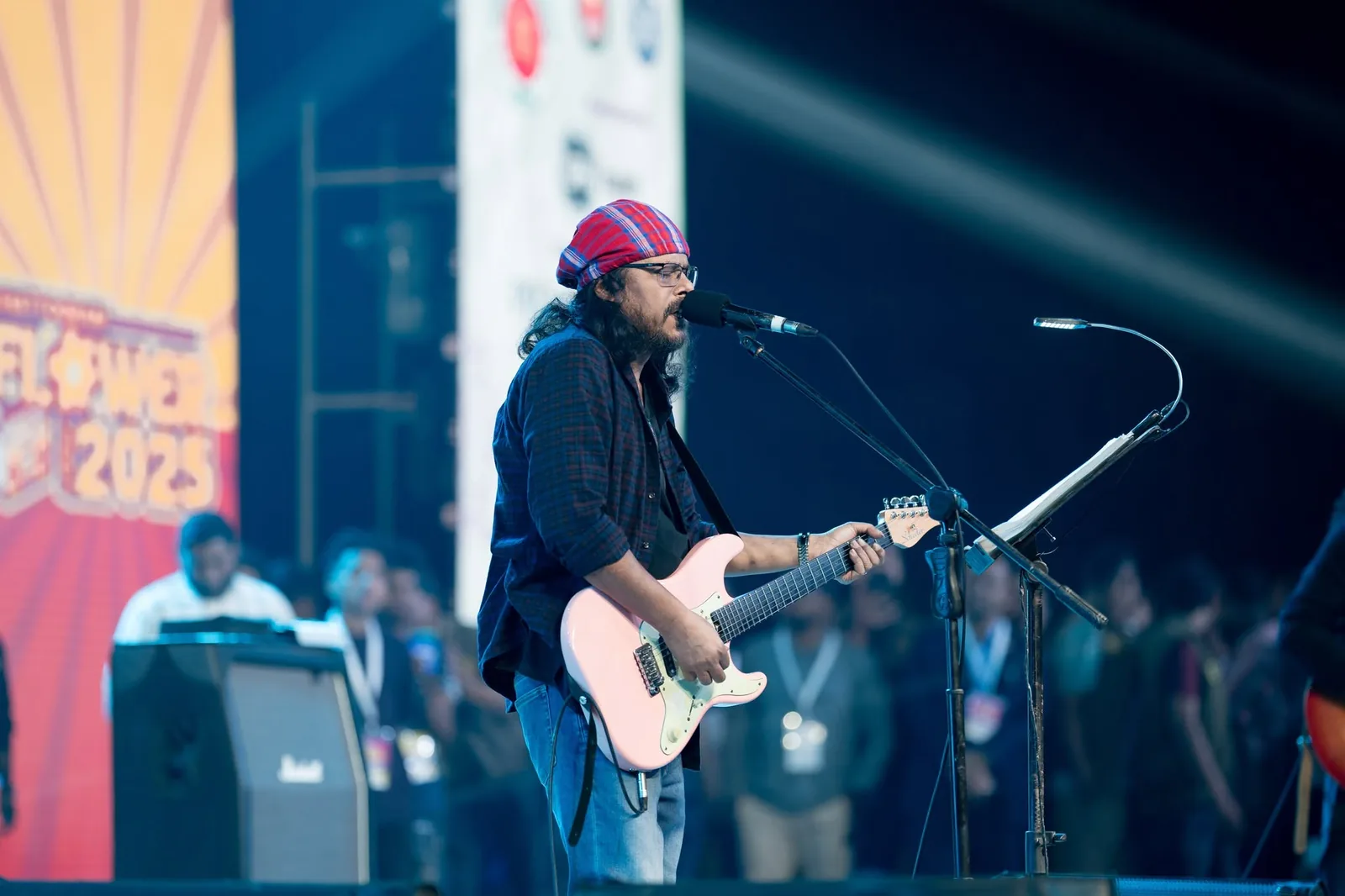 Singer playing guitar on stage at Flower Fest Chattogram